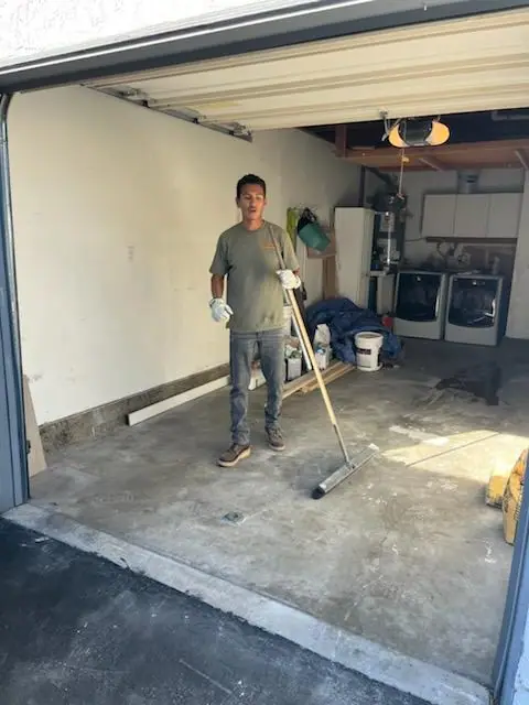 Crew member squeegeeing an empty, clean garage floor