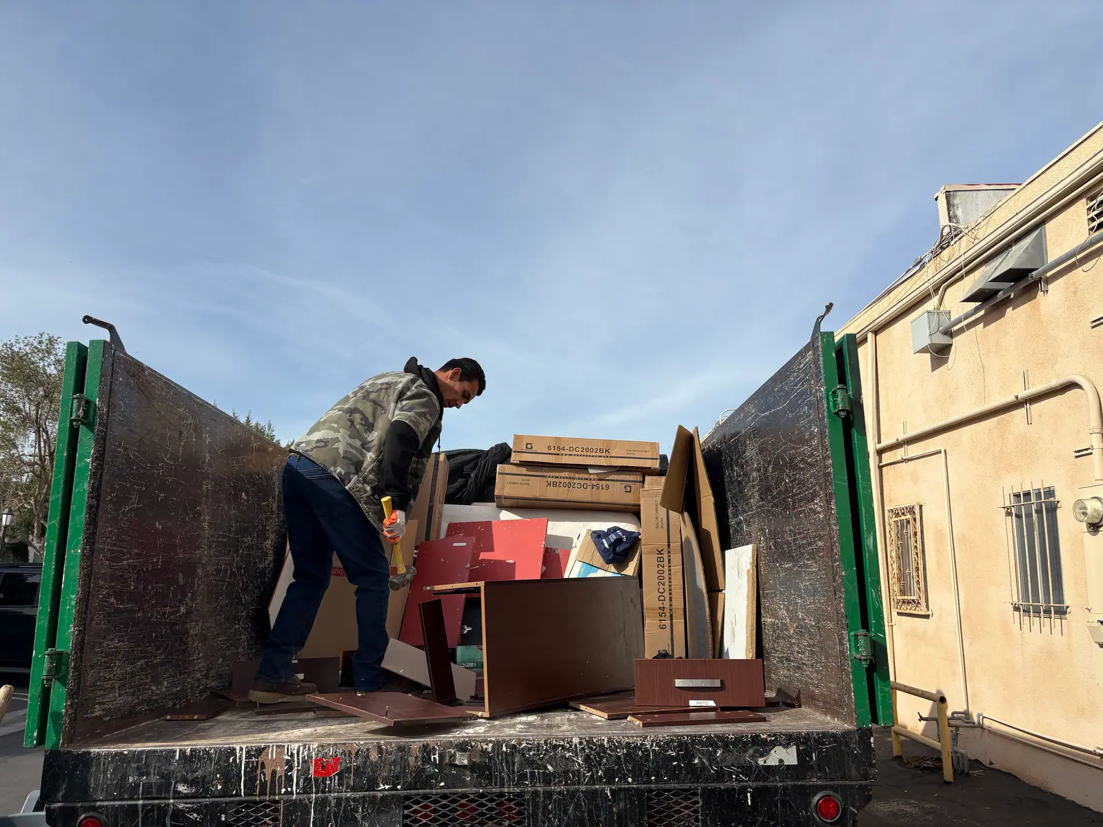 Crew member loading boxes and furniture panels into the truck bed
